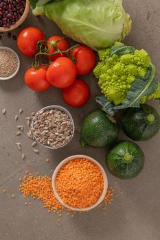 Healthy food selection with vegetables, seeds, superfood, cereals on kitchen countertop.