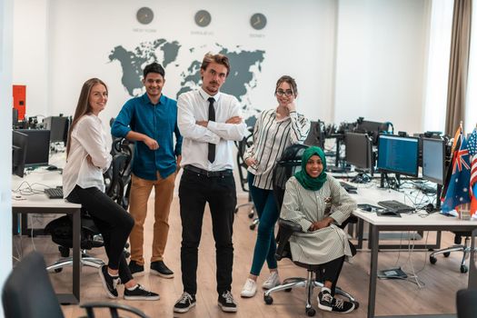 Portrait of young excited multiethnics business team of software developers standing and looking at the camera at modern startup office. High-quality photo