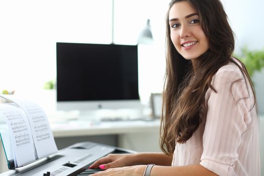 Woman is learning to play home synthesizer. Learning music concept