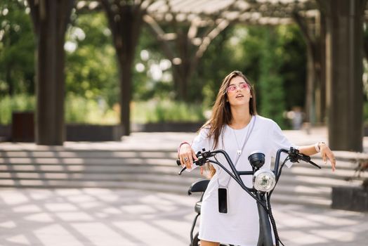 Young beautiful woman and an electric scooter, modern girl, new generation, electric transport, ecological transport