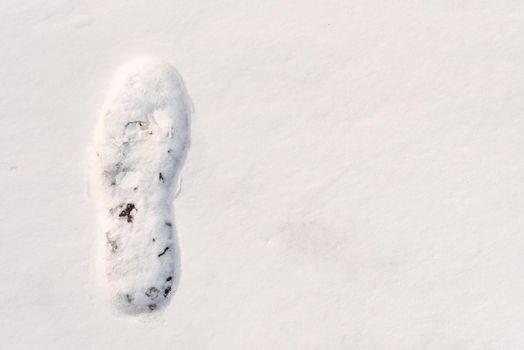 footprints on the snow under sunlight close-up with copy space.