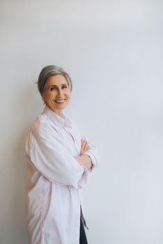 Smiling confident middle aged business woman standing isolated on white background.
