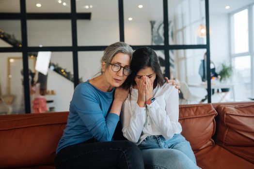 Grandmother comforting her sad granddaughter at home. Support concept
