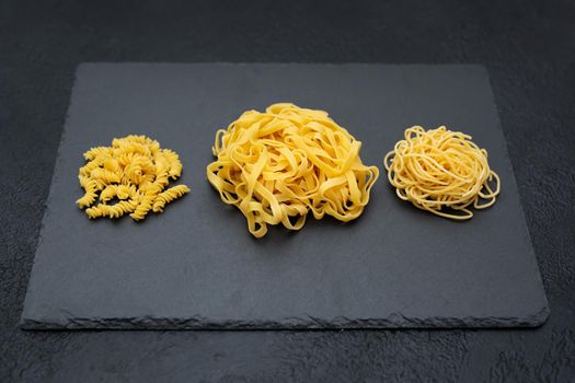 Raw pasta, isolated on a black background, top view.