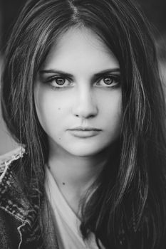 black and white portrait of a teenage girl with long hair on a nature background
