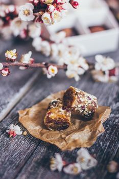 Spring collection of handmade chocolate bonbons candies and cherry flowers decoration on rustic wooden background.