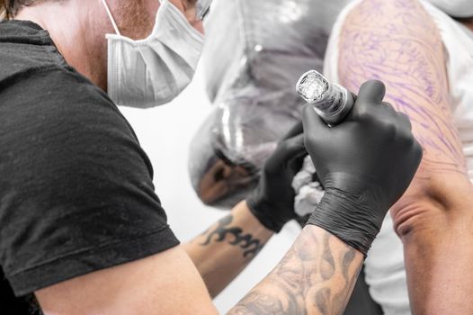 Tattoo artist making tattoo at the studio. High quality photography