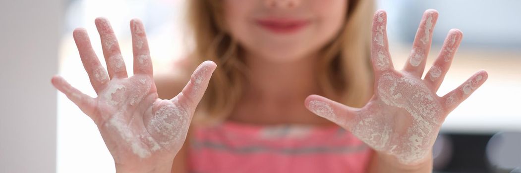 Little girl shows hands in flour. Cooking class for children concept