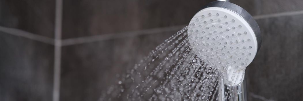 Running water pours from chrome-plated shower mixer. Bathroom fixtures concept