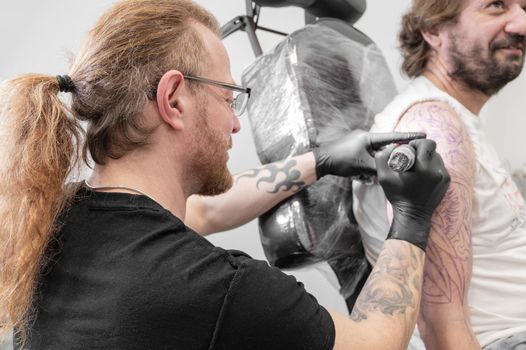 Salon tattoo. Close up of a Tattoo artist working. Tattoo artist make tattoo at the studio. High quality photography.