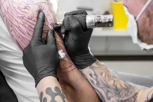 Salon tattoo. Close up of a Tattoo artist working. Tattoo artist make tattoo at the studio. High quality photography.