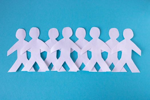 People cut out of paper on a blue background. The concept of the World Peace Day