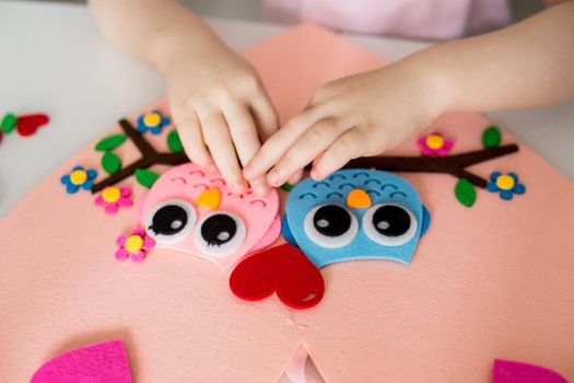 A blogger girl makes a felt craft for Valentine's Day in the shape of a heart. The concept of children's creativity and handmade.