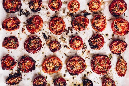 Prepared Sun Dried Tomatoes with Olive Oil and Herbs on Parchment Paper. View from Above.