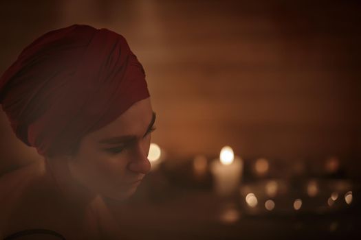 A woman performs a Tibetan ritual with sound bowls. Face close-up.