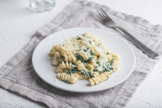 Creamy Spinach Fusilli Pasta with Ricotta and Parmesan on White Plate