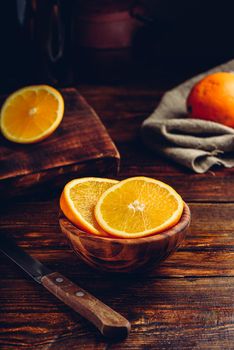 Slices of orange in a rustic wooden bowl
