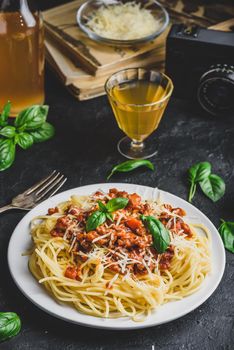 Spaghetti with bolognese sauce, grated parmesan cheese and fresh basil leaves