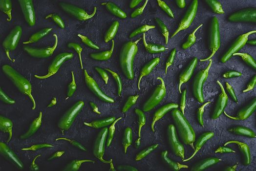 Background of Raw Green Jalapeno Peppers on Dark Concrete Surface