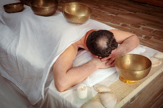 Men perform Tibetan rituals with sound bowls.