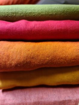 Detailed close up view on samples of cloth and fabrics in different colors found at a fabrics market.