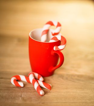 Mug Of Tea Or Coffee. Sweets. Christmas Decorations. Red Balls And Bells. Wooden Background.