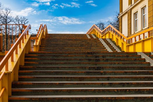 Old concrete and steel stairs to small footbridge over street