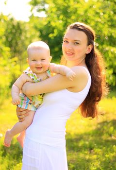 Beautiful Mother And Baby outdoors. Nature. Beauty Mum and her Child playing in Park together