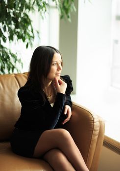 Young pretty business woman in the bright modern office indoors