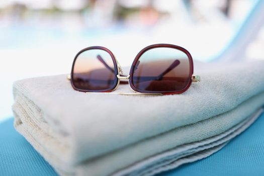 Close-up of stylish sunglasses on towel, accessory for good summertime rest. Set for day on beach. Summer, resort, relaxation, fashion, accessory concept