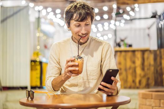 Man drinking cold bubble tea in cafe.