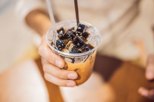 Man drinking cold bubble tea in cafe.