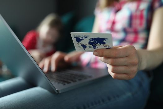 Close-up of woman typing on keyboard, holding credit card, pay online remotely, shopping on laptop from home. Online shopping, contactless payment concept