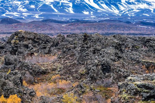 Vast Dimmuborgir lava field with snow covered mountains in the background