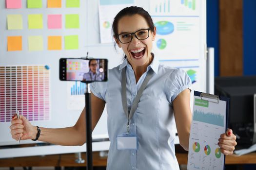 Portrait of happy businesswoman finish statistics report, laugh and celebrate successful well done job. Record speech on camera. Business, strategy concept