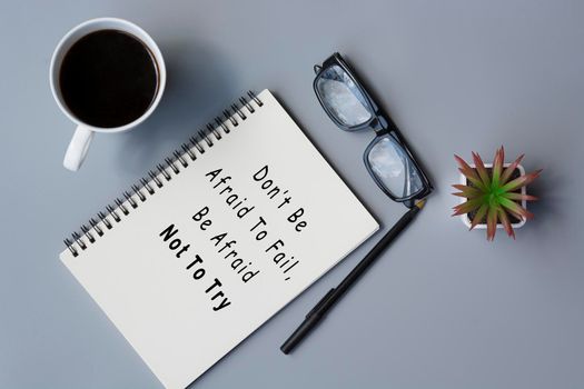 Motivational quote on notepad - Do not be afraid to fail, be afraid not to try.