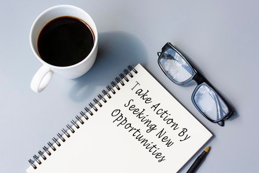 Motivational quote on notepad - Take action by seeking new opportunities. Action plan concept.