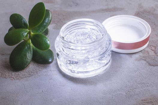 transparent jar with moisturizing gel with hyaluronic acid on a concrete background
