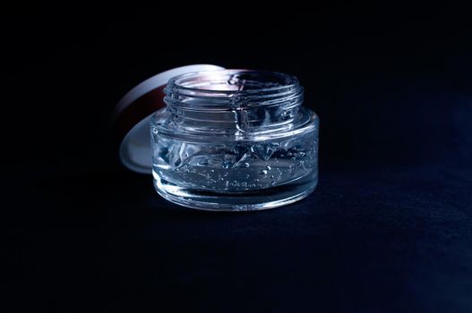 transparent jar with moisturizing cream with hyaluronic acid on a black background