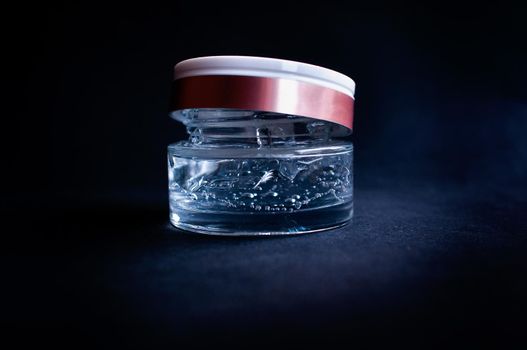 transparent jar with moisturizing cream with hyaluronic acid on a black background