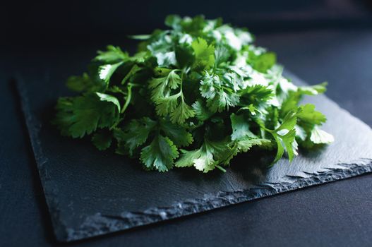fresh dill and parsley lies on a black board