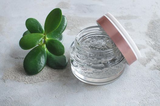 transparent jar with moisturizing cream with hyaluronic acid on a concrete background