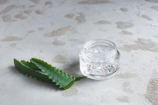 transparent jar with moisturizing cream with hyaluronic acid on a concrete background