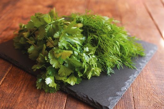 fresh arugula dill and parsley lies on a black board
