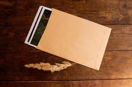 photos are enclosed in a beige envelope, located on a brown wooden table