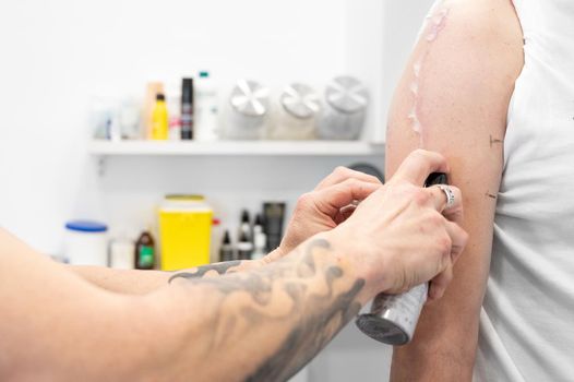 Tattoo process, Tattooist applying gel to client arm. High quality photo