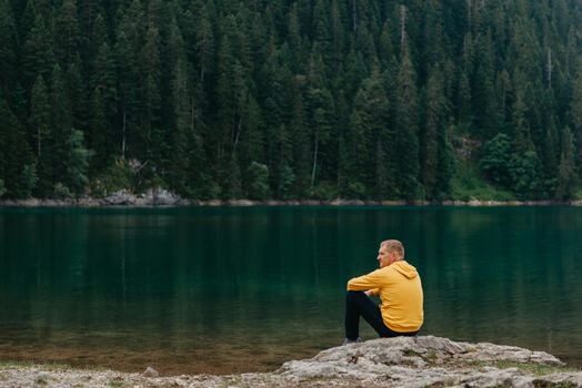 Traveler Man relaxing meditation with serene view mountains and lake landscape Travel Lifestyle hiking concept summer vacations outdoor