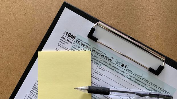 1040 tax form with pen sticky note. Conceptual