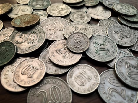 Isolated old coin on brown wooden table.