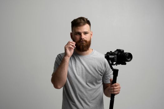 Bearder videographer filmmaker cinematographer dop with 3-axis gimbal and dslr camera. Filmmaking, videography, hobby and creativity concept.